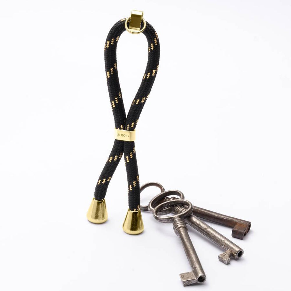 Schwarzer Schlüsselanhänger mit goldenen Verzierungen, sowe goldenem Slider und Endstücken.