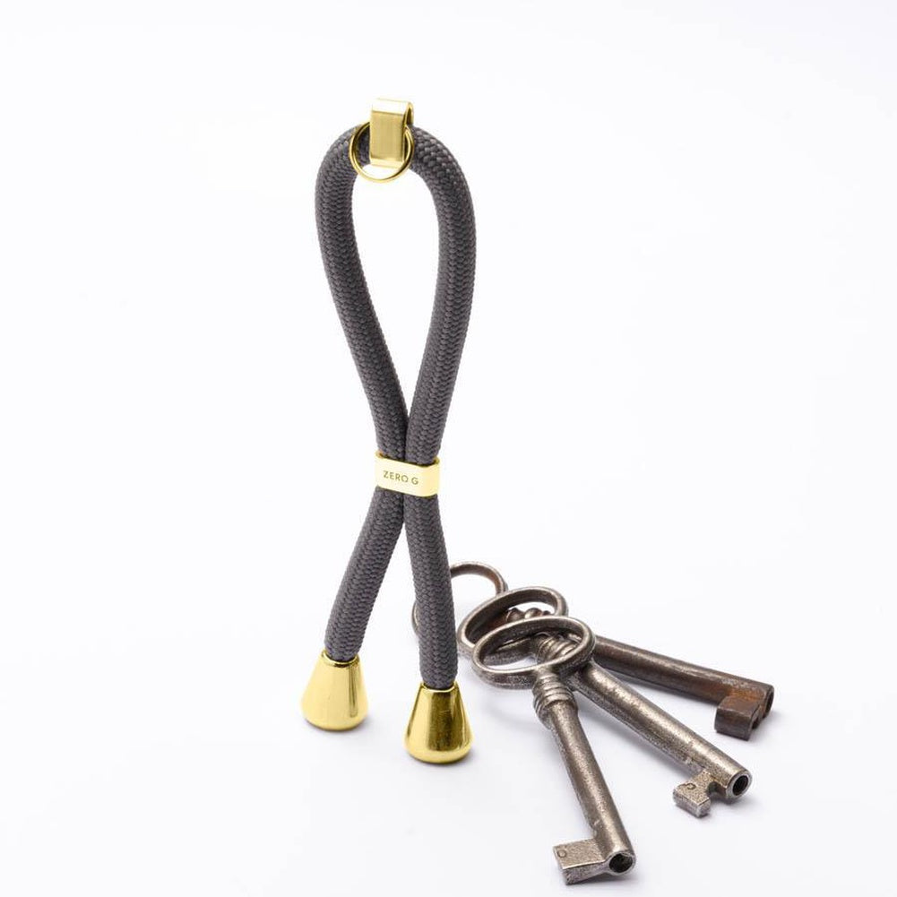 Grauer Schlüsselanhänger mit goldenem Slider und Endstücken.