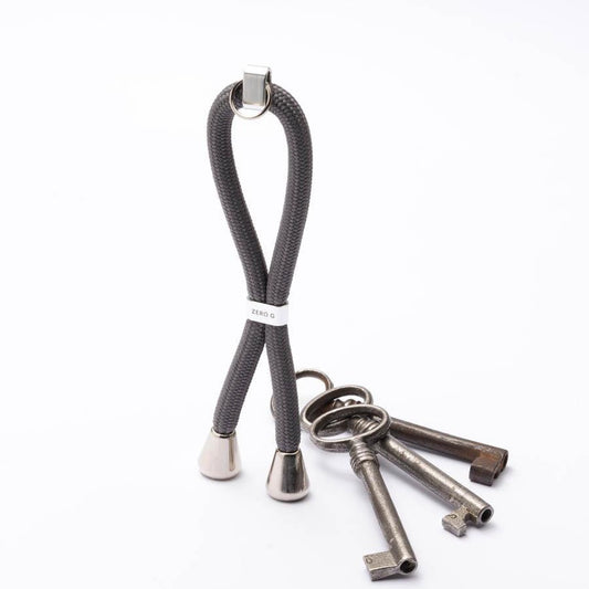 Grauer Schlüsselanhänger mit silbernem Slider und Endstücken.