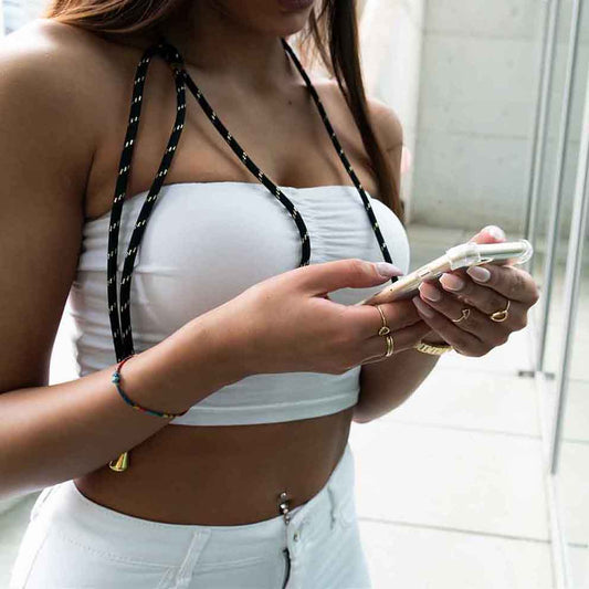 Frau hält Handy in den Händen mit schwarzer Handykette und Goldverzierungen.