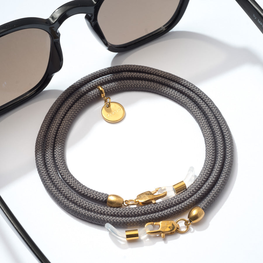 Sonnenbrille mit dunkelgrauen Brillenband und goldenen Metall Elementen
