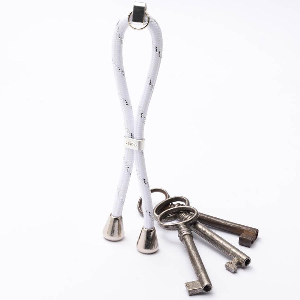 Weißer Schlüsselanhänger mit silbernen Verzierungen, sowie silbernem Slider und Endstücken.