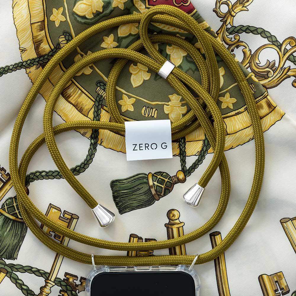 Khakifarbene Kordel mit ZERO G Logo und goldenen Akzenten auf gemustertem Untergrund.